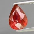 Natural gemstone orange Padparadscha sapphire on gray background