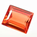 Natural gemstone orange Padparadscha sapphire on gray background