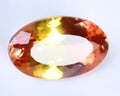 Natural gemstone orange Padparadscha sapphire on gray background