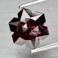 Natural gemstone red rhodolite garnet on gray background