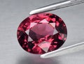 Natural gemstone red rhodolite garnet on gray background