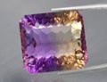 Natural gemstone yellow purple ametrine on a gray background. Purple variety of quartz