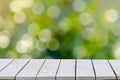 Natural green background with selective focus. The green background has a bokeh leaf and grass on a white wooden floor. Empty tabl Royalty Free Stock Photo