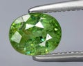 natural green demantoid garnet gem on the background
