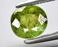 natural green demantoid garnet gem on the background