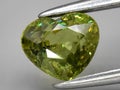 natural green demantoid garnet gemstone on the background