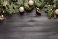 Natural green pine tree with golden baubles and decor on black wooden background, copy space, top view. Christmas border with Royalty Free Stock Photo