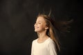 Natural hair. Girl kid long hair flying in air, black background. Child with natural beautiful healthy hairstyle