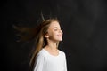 Natural hair. Girl kid long hair flying in air, black background. Child with natural beautiful healthy hairstyle