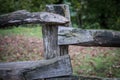 Natural hand made fence made of wooden tree brenches. Close up view of village fence with moss on wooden surface