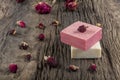 Natural hand made soap with dry pink roses on vintage wooden board. Spa