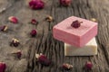 Natural hand made soap with dry pink roses on vintage wooden board. Spa