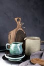 Natural handcrafted dishware. Wooden brown cutting board and ceramic blue cream jug, gray linen napkin. Country, rustic style