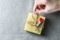 Natural handmade soap with a heart decor on a background of linen fabric. Children`s hands hold natural soap