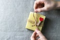 Natural handmade soap with a heart decor on a background of linen fabric. Children`s hands hold natural soap