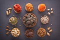 Natural healthy raw energy bites, chocolate paste and mix of dried fruits with nuts on a dark table. Royalty Free Stock Photo