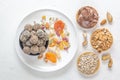 Natural healthy raw energy bites, chocolate paste and mix of dried fruits with nuts on a white table. Royalty Free Stock Photo