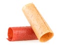 Natural and healthy snack food - multicolored tubes of fruit pastille from apples and raspberry on a white background