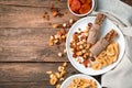 Natural, healthy sweets. Granola bar, nuts, dried fruits in a white plate on a wooden brown background. Royalty Free Stock Photo