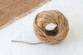 Natural hemp cord ball and burlap on a rough white surface. Roll of jute string or flax twine. Coarse rustic thread for souvenirs Royalty Free Stock Photo