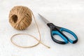 Natural hemp cord ball and scissors on a rough white surface. Roll of jute string or flax twine. Coarse rustic thread for Royalty Free Stock Photo