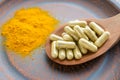 Natural herb food supplement turmeric veggie capsules and spoon