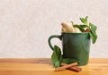 Natural herbal ingredients in mug on wooden table