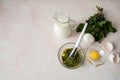 Nettle dioecious, milk, egg yolk and ready-made mask in a cup with a spatula close-up on a pastel pink marble background. Royalty Free Stock Photo