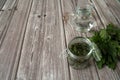 Leaves of nettle dioecious, vodka in a jug and ready-made tincture of nettle in a jar on a wooden background. Royalty Free Stock Photo