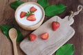 Natural homemade plain organic yogurt mixed with fresh berry fruit in wood bowl and wood spoon on wood table background Royalty Free Stock Photo