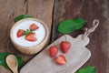 Natural homemade plain organic yogurt mixed with fresh berry fruit in wood bowl and wood spoon on wood table background Royalty Free Stock Photo