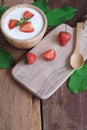 Natural homemade plain organic yogurt mixed with fresh berry fruit in wood bowl and wood spoon on wood table background Royalty Free Stock Photo