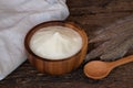 Natural homemade plain organic yogurt in wooden bowl and wood spoon on wood texture background Royalty Free Stock Photo