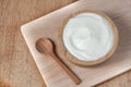 Natural homemade plain organic yogurt in wooden bowl and wood spoon on wood texture background Royalty Free Stock Photo