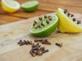 Natural homemade repellents on wooden table. Lime and lemon with cloves