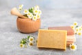 Natural homemade soap with chamomile flowers on a wooden table.