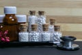 Natural Homeopathy Concept - A Stethoscope with homeopathic medicine bottles consisting of pills and liquid substance with pink