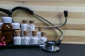 Natural Homeopathy Concept - A Stethoscope with Homeopathic medicine bottles consisting pills and liquid substance and pink flower Royalty Free Stock Photo