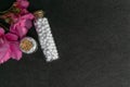 Natural homeopathy Concept - Top view of homeopathic medicine bottles with cork consisting of pills and pink flowers on dark