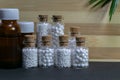 Natural Homeopthy concept - Homeopathy medicine bottles of pills and liquid substance with green leaf on wooden and dark