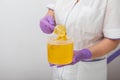 Natural honey sugar paste shugaring closeup. Women beautician holds jar wax of paste for sugar depilation shugaring Royalty Free Stock Photo