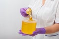 Natural honey sugar paste shugaring closeup. Women beautician holds jar wax of paste for sugar depilation shugaring Royalty Free Stock Photo