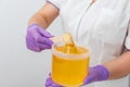 Natural honey sugar paste shugaring closeup. Women beautician holds jar wax of paste for sugar depilation shugaring