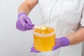 Natural honey sugar paste shugaring closeup. Women beautician holds jar wax of paste for sugar depilation shugaring Royalty Free Stock Photo