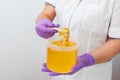 Natural honey sugar paste shugaring closeup. Women beautician holds jar wax of paste for sugar depilation shugaring Royalty Free Stock Photo