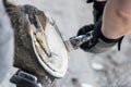 Natural hoof trimming - the farrier trims and shapes a horse`s hooves using the knife, hoof nippers, rasp.