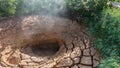 A natural hot spring is a mud pot. There are deep cracks on the clay edges. Royalty Free Stock Photo