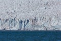 Ice front of Esmarkbreen glacier in Spitsbergen in sunshine, blue sea