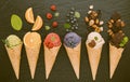 Icecreams with fruit and nut ingredients - ice cream cones on a black background