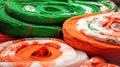 Natural Indian fabrics in orange, white, green colors for sewing traditional festive clothes, rolled into large rolls